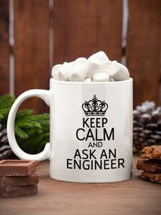 a white coffee mug filled with marshmallows on top of a table