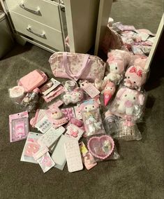 many hello kitty toys are laying on the floor next to a dresser and drawers in an office