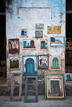 three chairs are sitting in front of a wall with pictures on it