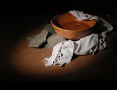 a wooden bowl sitting on top of a table next to a white cloth covered napkin