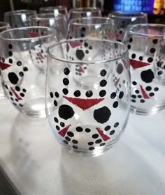 several glasses with black and red designs on them