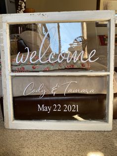 a welcome sign is placed in front of a window