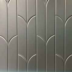 an image of a wall that is made out of silver metal panels and has decorative designs on it