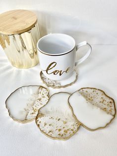 white and gold coasters with love written on them