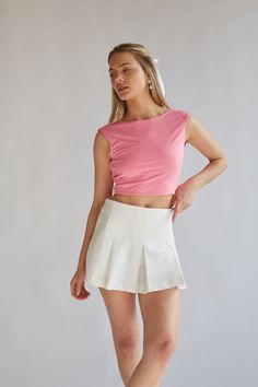 Maggie Tie Back Crop Top is the perfect elevated basic! This cute top features a sleeveless bodice, high neckline, cropped fit, and an open back with an adjustable tie. Available in white and pink. Pair with a cute mini skirt to complete the look! Details 95% Polyester, 5% Spandex Double lined Hand wash cold / Line dry Pink Fitted Top With Short Length, Pink Fitted Short Length Tops, Pink Fitted Short-length Tops, Fitted Short Length Pink Tops, Chic Pink Short Length Top, Chic Pink Short-length Tops, White Fitted Sleeveless Crop Top, Feminine Stretch Cropped Top, White Fitted Short Tank Top