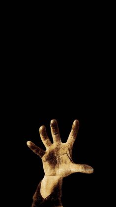 a person's hand reaching up into the air in front of a black background