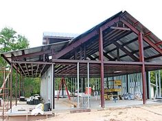 a metal frame building being built on the side of a road