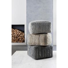 three stacked logs in front of a fireplace