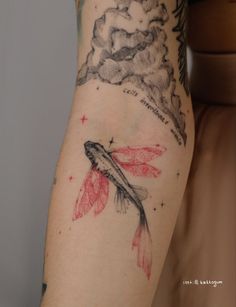 a woman's arm with a red and black koi fish tattoo on it