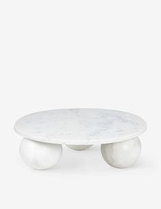 an oval marble table with two white balls on the top and one round in the middle