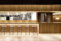 an empty bar with stools in front of it and lights on the wall above