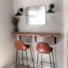 two bar stools sit in front of a mirror on the wall next to each other