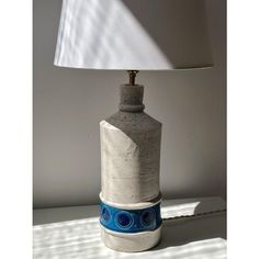 a lamp that is on top of a table next to a white wall and floor