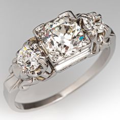 a three stone diamond ring with an old - fashioned style setting on the shoulders and sides