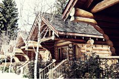 a log cabin with stairs leading up to the front door and windows on each side