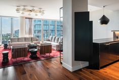 a living room filled with furniture and tall windows