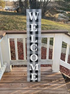 a wooden welcome sign sitting on top of a porch