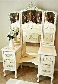 a white vanity with drawers and a mirror