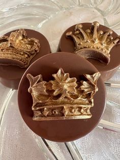 three chocolates with gold crown decorations on them