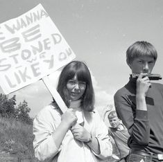 black and white photograph of two people holding protest signs