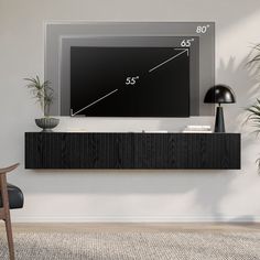 a flat screen tv mounted to the side of a wall next to a chair and potted plant