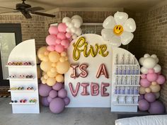 there are balloons on the wall and in front of the sign that says five is a vibe