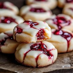 cranberry shortbreads with white icing and red toppings on a piece of parchment paper