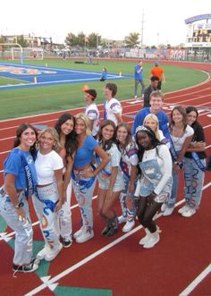 a group of young women standing on top of a track