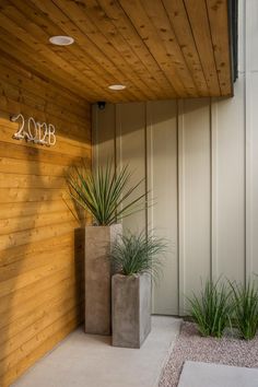 a building with two planters in front of it and a sign on the wall