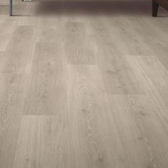 a living room with wood flooring and white furniture in the background on a wooden floor