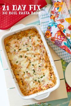 a casserole dish with meat and cheese in it sitting on a table next to an oven mitt