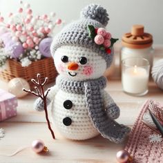 a crocheted snowman sitting on top of a table next to other items