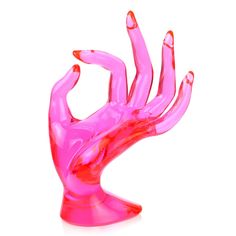 a pink glass hand sculpture sitting on top of a table