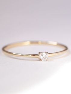 A luminous quintessential beauty. This petite four-prong ring features a sparkling diamond. It's set in a dainty ring that can be worn from day to night. Delicate Diamond Ring Vs Clarity, Dainty Diamond Ring With Vs Clarity, Delicate Diamond Stackable Rings With Vs Clarity, Diamond White Stackable Rings With Single Diamond, Elegant 14k Gold Birthstone Ring With Diamond, Minimalist Diamond White Stackable Rings With Vs Clarity, Minimalist Diamond White Diamond Ring With Round Band, Simple Diamond Ring As Gift, Minimalist Vs Clarity Stackable Rings In Diamond White