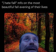 a man is looking up at the sky in front of trees with leaves on them