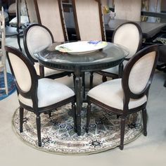 a glass table with six chairs around it in a room filled with furniture and rugs