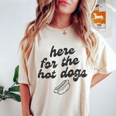 Here For The Hot Dogs Shirt, Hot Dog T-Shirt, Tailgate Shirt, Baseball T-Shirt, Gift for Hot Dog Lovers, Summertime Hot Dog Shirt This classic unisex jersey short sleeve tee fits like a well-loved favorite. Soft cotton and quality print make users fall in love with it over and over again. These t-shirts have-ribbed knit collars to bolster shaping. The shoulders have taping for better fit over time. Dual side seams hold the garment's shape for longer.  .: 100% Airlume combed and ringspun cotton (fiber content may vary for different colors) .: Light fabric (4.2 oz/yd² (142 g/m .: Retail fit .: Tear away label .: Runs true to size, size UP 1-3 sizes for an oversized look *Unfortunately, we do not accept exchanges, cancellations, or returns since each product is made to order. If you notice an Hot Dog Shirt, Cotton Short Sleeve T-shirt With Dog Print, Summer Short Sleeve T-shirt With Dog Print, Dog Print Crew Neck Graphic Tee, Summer Dog Print Graphic Tee, Summer Dog Print Short Sleeve Top, Short Sleeve Dog Print Top For Summer, Summer Dog Print Relaxed Fit T-shirt, Summer Relaxed Fit T-shirt With Dog Print