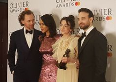 three people standing next to each other on a red carpet