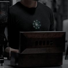 a man standing in front of a computer with a clock on it's face