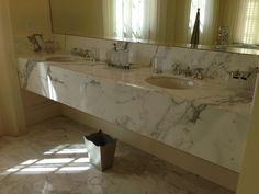 a bathroom with marble counter tops and two sinks