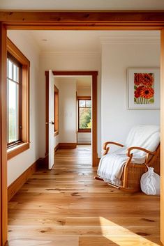 an open door leading to a bedroom with wood floors and white walls, along with a wooden rocking chair in the foreground