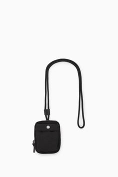 This black mini pouch has practical features in abundance, but it'll make a nice finishing touch to your outfit, too. Sized to fit the essentials, it's crafted from hardwearing nylon-ripstop and has a slip pocket to store your cards, a snap-stud flap pocket, a secure zipper and a corded key fob. The strap can be adjusted using the leather keeper; wear it around your neck or slung across one shoulder as a crossbody. Zip closureRecycled nylon reduces our demand on limited natural resources and reduces greenhouse gas emissions 55% Recycled polyamide (Recycled nylon), 45% Recycled polyester  Height: 4.33", Width: 3.34", Depth: 0.78" Functional Black Pouch For Outdoor Activities, Functional Nylon Pouch For Everyday Use, Functional Black Pouch For Everyday Use, Functional Mobile Pouch, Functional Nylon Pouch With Zipper Pocket, Functional Nylon Pouch For Daily Use, Black Pouch With Zipper Pocket For Outdoor, Functional Black Everyday Pouch, Practical Black Pouch With Pockets