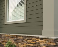 the side of a house with a stone wall and window