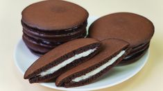 chocolate cookies with cream filling on a white plate