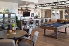 a pool table sitting in the middle of a living room filled with furniture and decor