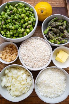 bowls filled with rice, asparagus, and other ingredients next to an orange