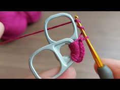 someone is knitting yarn with a pair of glasses