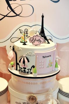 a three tiered cake is decorated with the eiffel tower and paris symbols