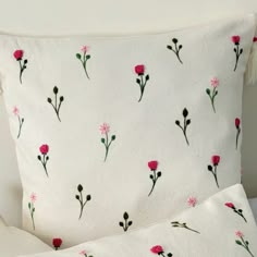 a white pillow with pink flowers on it