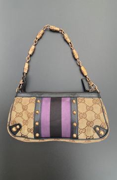 All Reserve items are final sale. This petit pouchette is a product of Tom Ford's helm at Gucci circa 05'/06'. Truly striking, with signature GG canvas and black leather trim, a purple/black stripes, and rose gold-tone hardware. A detachable chain strap, zip closure, and interior with an open pocket. Carry this style hand-held or on the forearm. Comes with dust bag. Condition: EXCELLENT/VERY GOOD Dimensions: Drop: 5.75" Height: 4" Width: 8" Depth: 1.5" *** Our scale is based on the following: Excellent Items look visually unused. Very Good Items show minor signs of wear. Good Items show moderate signs of wear. Shoes may show wear such as moderate scuffing at the soles, insoles and heels. Handbags and accessories may show wear such as worn corners, moderate scratches and interior wear. Fair Tom Ford For Gucci, Unique Purses, Chic Leather, Gucci Black, Purple Black, Leather Trim, Chain Strap, Black Stripes, Tom Ford